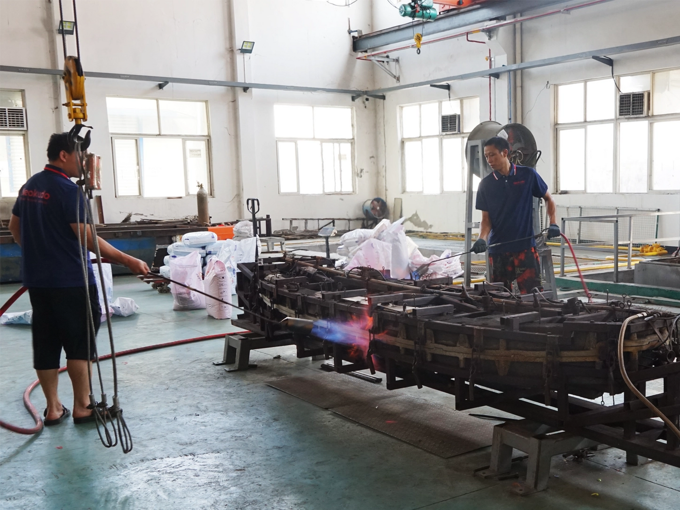 KUDO Outdoors factory workers operating kayak rotomolding equipment in the production workshop